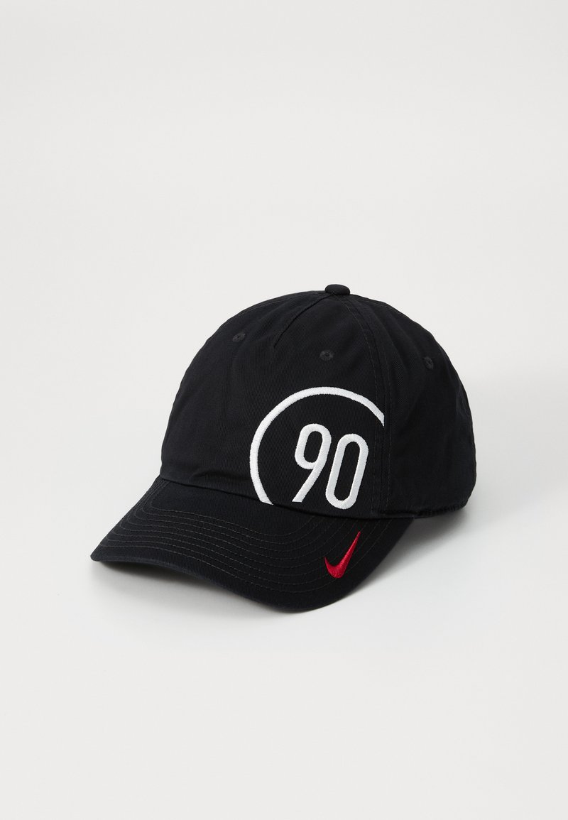 Sort baseball cap med hvid broderet '90' inden i en cirkulær kontur, featuring et rødt Nike swoosh-logo på skyggen. Blød stofstruktur.