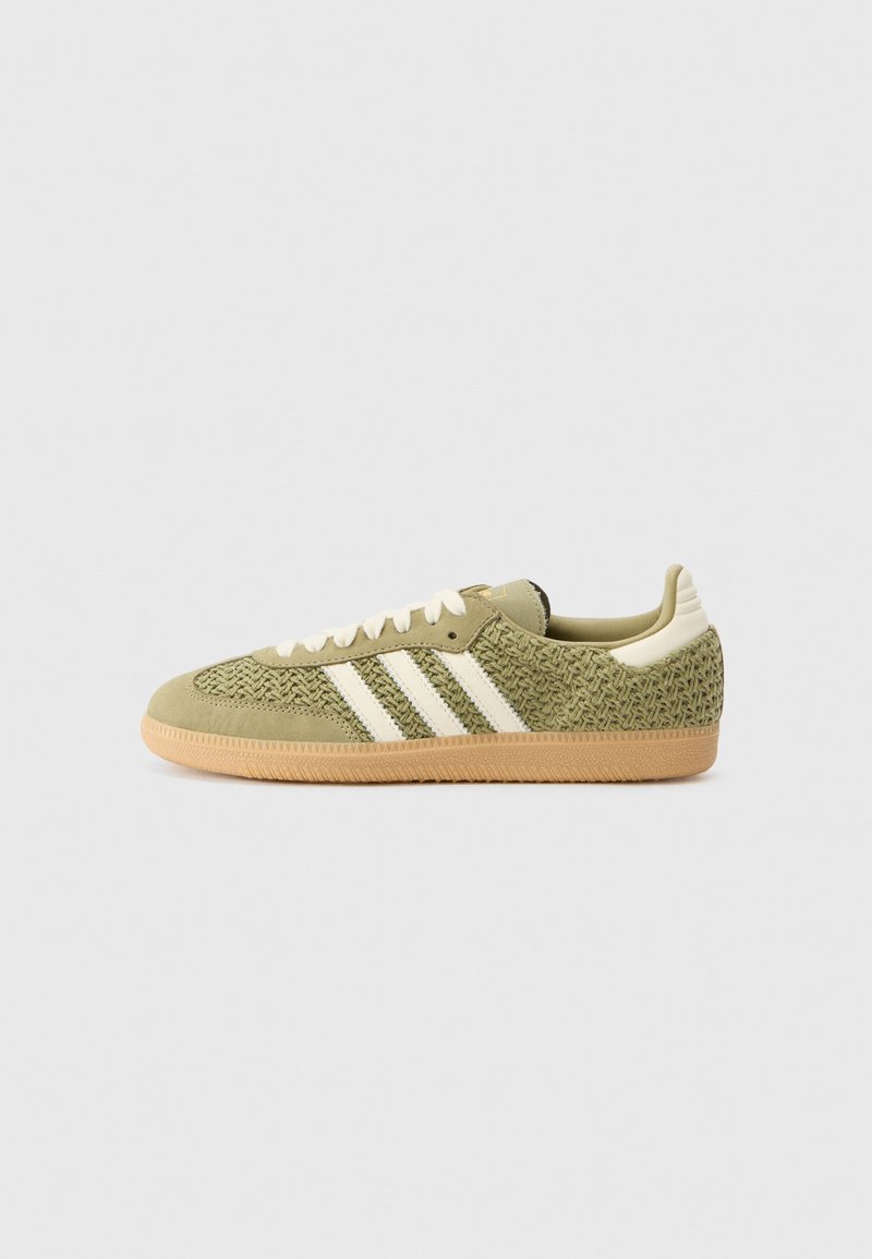 Grønne ruskinds sneakers med vævet tekstur, tre hvide striber, off-white snørebånd og en gummisål. Lav profil design med polstret krave.