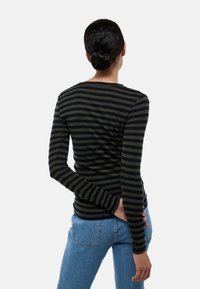 Chemise à manches longues rayée en vert foncé et bleu marine, avec un col rond et une coupe ajustée, fabriquée en matériau doux et extensible.