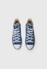 Höga sneakers i blå kanvas med vita snören, gummitåskydd och kontrasterande vit sömnad. Klassisk design med texturerat tyg.