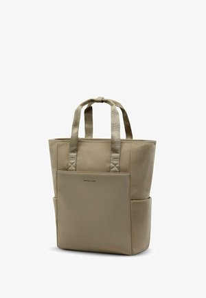 Sac fourre-tout beige avec côtés en tissu côtelé, poche avant lisse, deux poignées et poches latérales, debout sur fond blanc.