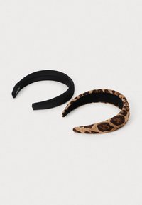Dva gumica za kos: ena črna enobarvna, druga s tkanino z leopardskim vzorcem na bež ozadju. Obe imata zaobljene konce in gladko teksturo.
