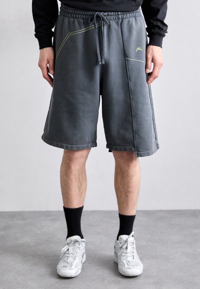 Graue Shorts mit lockerer Passform, Kordelzugbund, Seitentaschen und kontrastierenden gelben Nähten. Mit einer weichen Textur versehen.