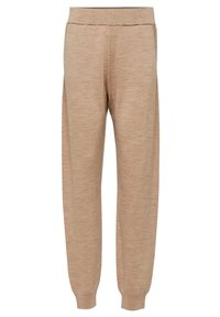 Béžové tepláky vyrobené z měkké tkaniny, s volným střihem, elastickým pasem a žebrovanými manžetami na kotnících pro bezpečné uchycení.