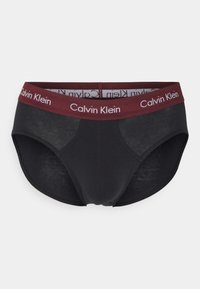 Schwarze Baumwollslips mit einem burgunderfarbenen Gummibund, der das "Calvin Klein"-Logo trägt. Glatte Textur und minimalistisches Design mit moderater Abdeckung.
