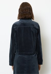 Tmavě modrá manšestrová bunda s dlouhými rukávy, límcem a zapínáním na knoflíky na manžetách, s krátkým střihem a strukturovanou tkaninou.