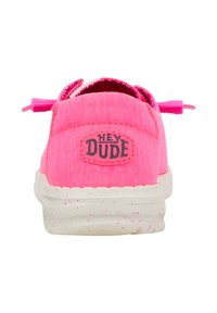 Chaussure slip-on en toile rose avec un tissu texturé, semelle blanche mouchetée et logo "HEY DUDE" au talon. Présente des lacets décoratifs.