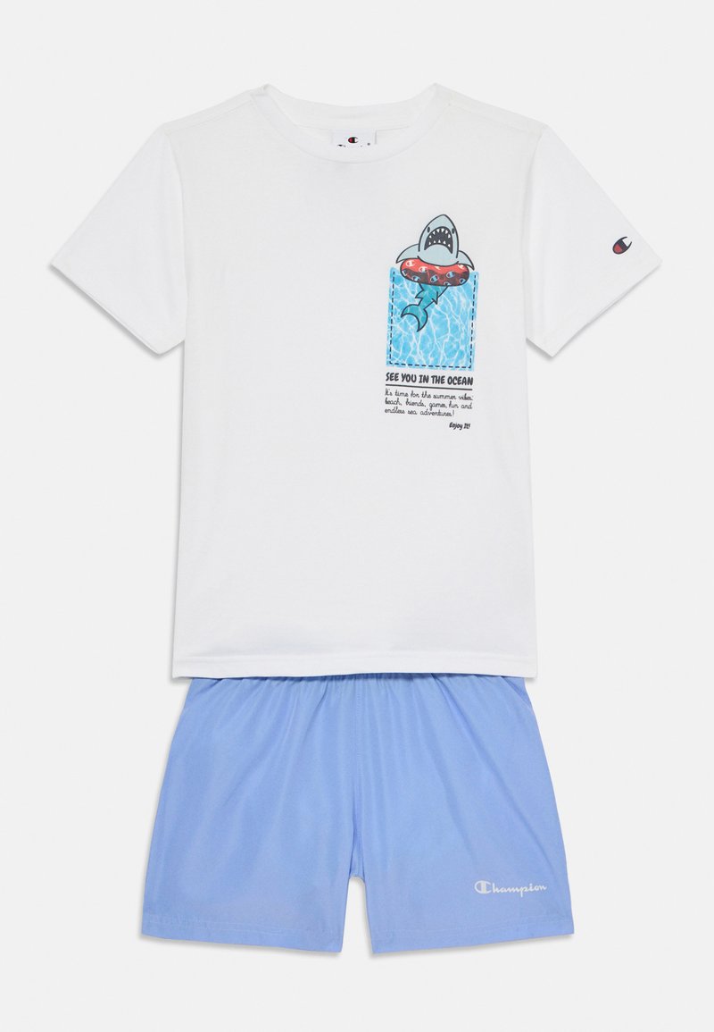 Camiseta de algodón blanca con gráfico de tiburón y texto, combinada con pantalones cortos de baño de color azul claro, con cintura elástica y detalle de logo.