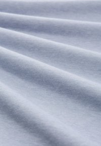 Tüll albastru deschis cu o textură fină, prezentat în pliuuri moi și detalii de prim-plan.