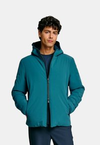 Giacca con cappuccio color verde acqua con zip frontale, caratterizzata da una texture liscia e polsini elastici. Leggera, con una vestibilità comoda e un design minimalista.