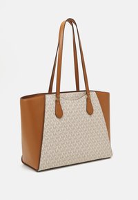 Sac fourre-tout en cuir brun avec un panneau crème à motifs présentant le logo MK répété. Deux longues poignées et des accents en métal doré.