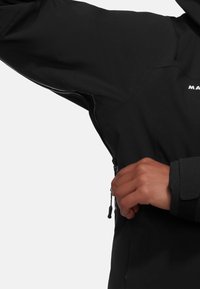 Schwarze wasserdichte Jacke mit einer Reißverschlusstasche und verstellbaren Manschetten. Glatte Textur mit einer taillierten Passform, geeignet für den Außenbereich.