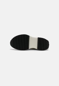 Czarną gumową podeszwę buta z wyraźnymi bruzdami, z białym środkowym paskiem. Na środkowej podeszwie wytłoczone logo "CONVERSE" dla oznaczenia marki.