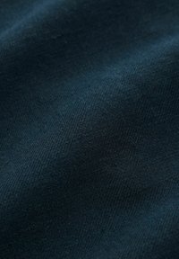 Dunkelblauer Stoff mit einer glatten Textur und subtilen Fischgrätenmuster, das eine feine Webart und eine weiche, matte Oberfläche zeigt.