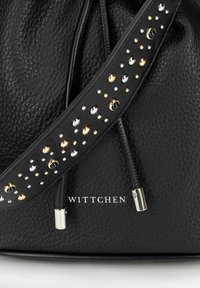 Sac à main en cuir noir avec une surface texturée, doté d'une bandoulière ornée de clous métalliques dorés, argentés et noirs. Logo de la marque affiché.