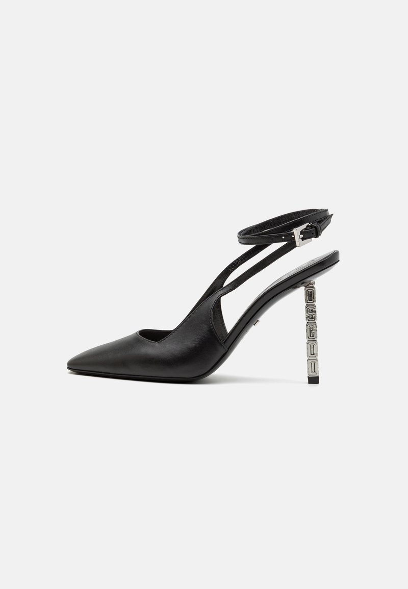 Zapato de tacón alto negro de piel con puntera puntiaguda y correa tipo slingback, y un tacón bloque texturizado de color plata. Superficie lisa con líneas mínimas.
