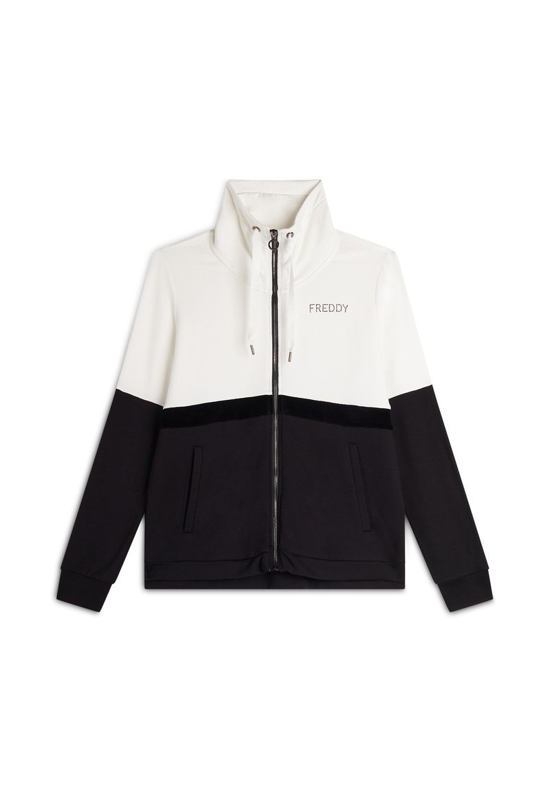Veste zippée avec un col haut, section supérieure blanche et section inférieure noire avec une bande en velours. Poches latérales incluses.