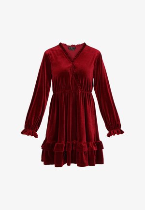 Abito in velluto rosso con maniche lunghe, dettagli arricciati lungo la scollatura e i polsini, e orlo a balze a più livelli, con vita aderente.