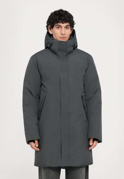 Graue Pufferjacke mit hohem Kragen, langen Ärmeln und seitlichen Taschen; zeichnet sich durch eine glatte, matte Textur und ein minimalistisches Design aus.