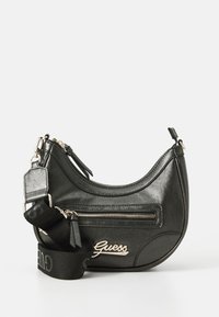 Borsa nera in ecopelle con forma arrotondata, dotata di una tasca frontale con zip, hardware argentato e una tracolla con logo rimovibile.