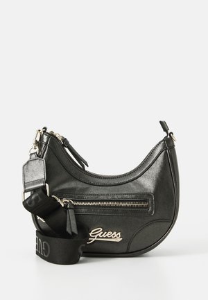 Sort faux læder håndtaske med en rund form, der har en frontlomme med lynlås, sølvfarvet hardware og en aftagelig logo-strop.