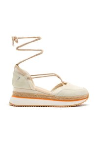 Baskets en suédine beige avec une semelle texturée beige et orange, dotées d'un lien chevillé en corde au niveau de la cheville et d'un design de sangle entrecroisée pour un meilleur soutien.
