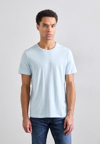 Tricou scurt, de culoare albastru deschis, din bumbac, cu guler rotund și textură netedă, asortat cu blugi din denim albastru.
