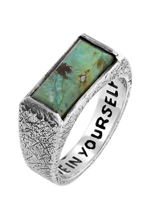 Silver ring with a textured band, featuring a prominent rectangular turquoise stone with brown and black inclusions. Inscribed interior text.