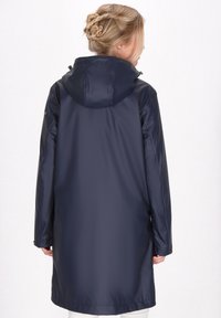 Marinblå vattentät parka med huva, långa ärmar och en avslappnad passform. Slät textur med justerbara manchetter och ryggventilation för andningsförmåga.