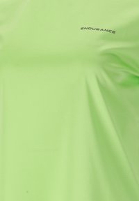 Limegrön atletisk T-shirt i lätt material, med rund halsringning och ordet "ENDURANCE" tryckt i svart nära axeln.