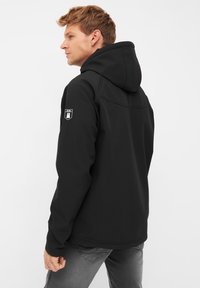 Felpa nera con collo alto e cappuccio, dotata di una patch del logo a contrasto sulla manica sinistra, tessuto liscio e design aderente.