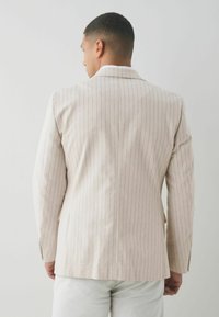 Beige Blazer mit Nadelstreifen in taillierter Passform, zwei Knöpfen, mit Revers und glatter Textur. Verfügt über traditionelle Designelemente.