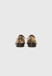Chaussures à motif de peau de serpent avec une combinaison de couleurs marron et beige, présentant un bout rond et un petit talon noir.