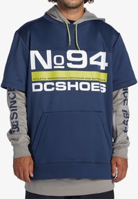 Mörkblå hoodie med grå långa ärmar, prydd med stora vita och gröna texter. Inkluderar en framficka och snörning i huvan. Slät textur.