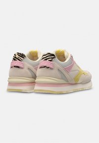 Sneakers met een beige en roze mesh bovenwerk, gele accenten en een zebra-patroon aan de achterkant. Gevoerde zool met gelaagde kleuren.