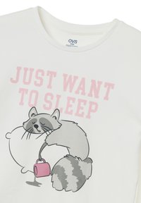 White cotton T-shirt featuring a cartoon raccoon hugging a pillow, with a pink text that says "JUST WANT TO SLEEP." Simple graphic design.