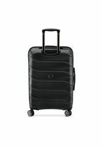 Black hard-shell suitcase with a textured finish, featuring a retractable handle, four wheels, and horizontal grooves on the surface.