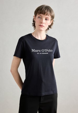 Must must särk, millel on ümmargune kaelus ja lühikesed varrukad, esiküljel on valge tekst "Marc O'Polo EST. IN STOCKHOLM".