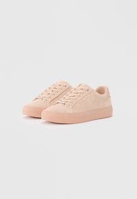 Sneaker in suede rosa con design a basso profilo, chiusura con lacci, dettagli metallici e suola in gomma coordinata. Texture liscia con branding minimale.