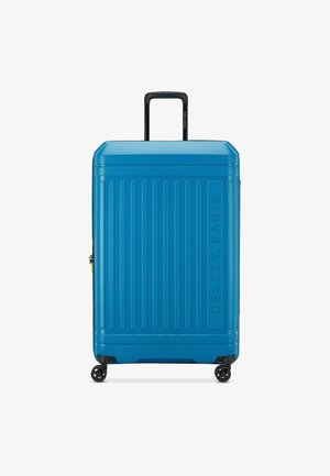 Valigia rigida blu con scanalature verticali, manico telescopico e quattro ruote. Presenta il logo Delsey Paris sul davanti.