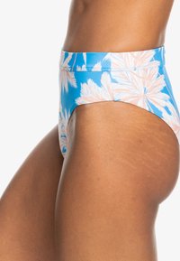 Blå högmidjad bikiniunderdel med ett vitt palmbladsmönster. Materialet verkar slätt med en lätt glans och visar en välsittande design.
