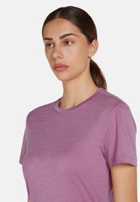 T-shirt lavanda a maniche corte realizzato in tessuto leggero, con una texture liscia e un classico design a collo rotondo. Senza motivi né dettagli.