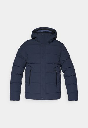 Casaco puffer azul marinho com capuz, apresentando textura acolchoada, dois bolsos com zíper e fecho de pressão na parte inferior.