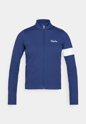 Mornarska biciklistička jakna s visokim ovratnikom, punim prednjim patentnim zatvaračem i bijelom trakicom na lijevoj rukavu, s "Rapha" logom.