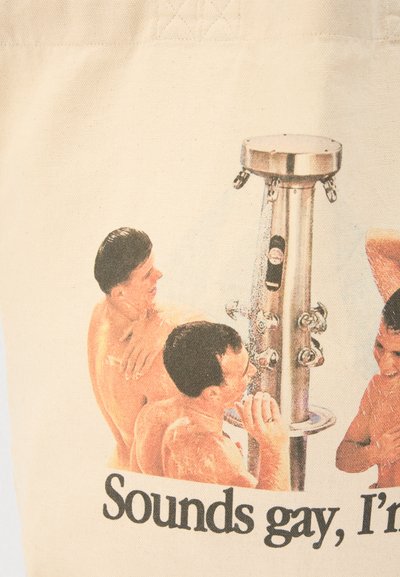 Βαμβακερή τσάντα tote με εκτυπωμένο σχέδιο τριών ανδρών χωρίς μπλούζες γύρω από μια μεταλλική ντουζιέρα, με κείμενο από κάτω.