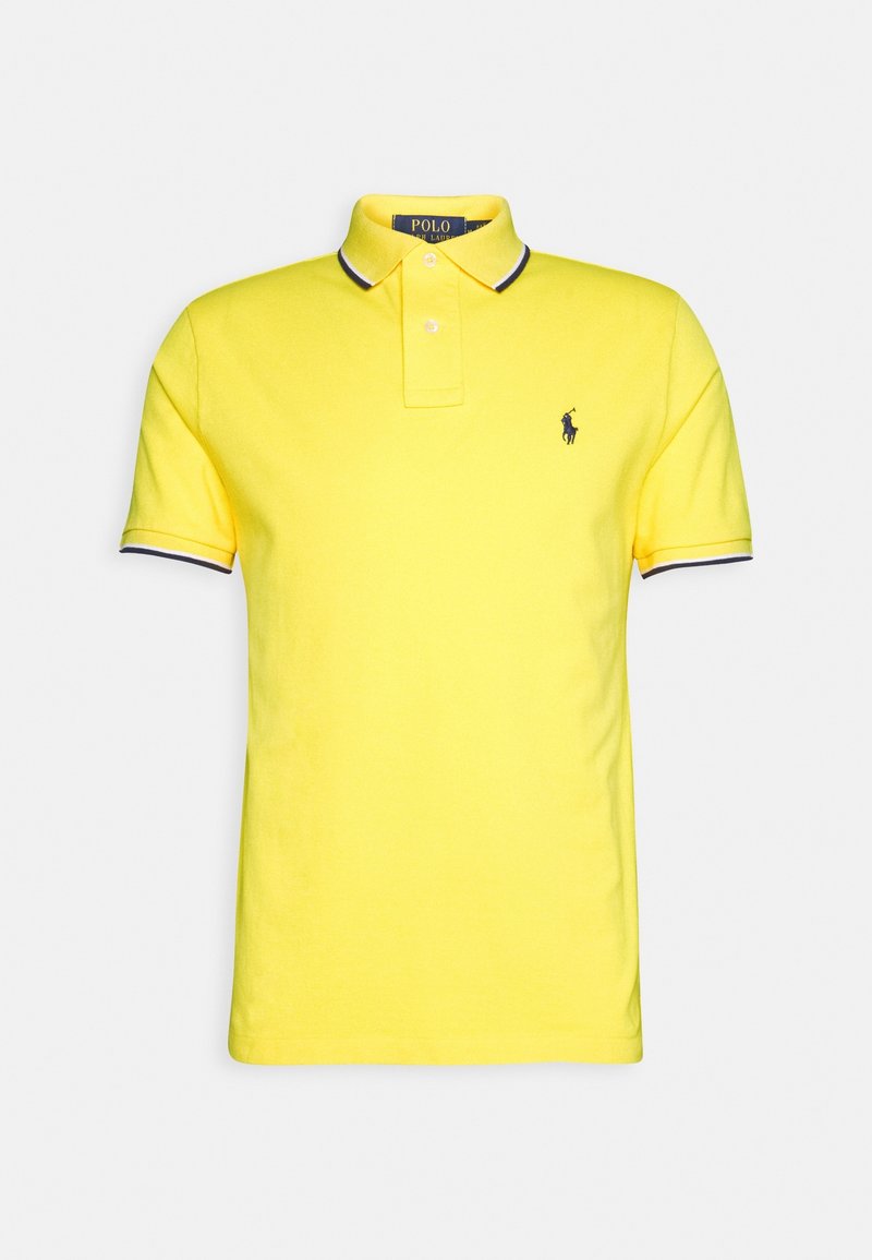 Polo shirt jaune en coton, avec un design classique comportant une patte de boutonnage à deux boutons et un col et des bords de manches rayés bleu marine. Logo sur la poitrine.