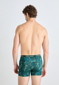 Männliche Boxershorts in Grün mit blauem tropischem Blattmuster, elastischem Bund, der mit "BJÖRN BORG" bedruckt ist, enganliegendem Design und weichem Stoff. 