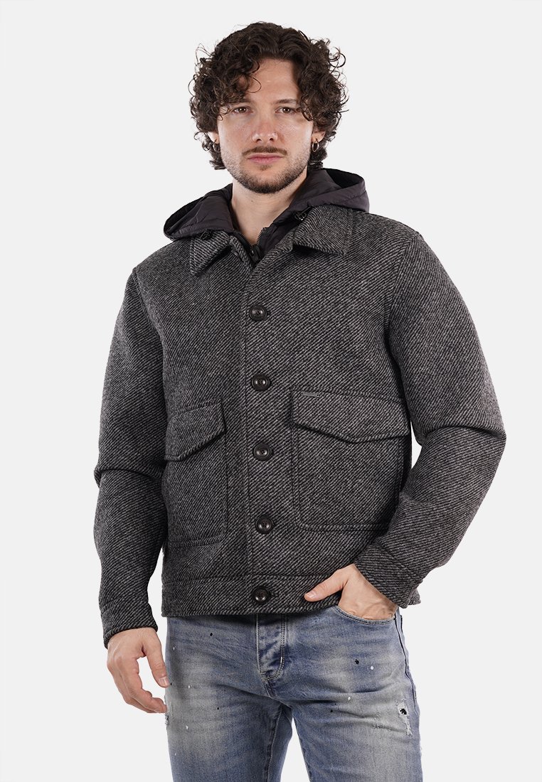 Giacca grigia a spina di pesce con colletto a camicia, due tasche frontali e cappuccio nero, caratterizzata da grandi bottoni e una vestibilità ampia.