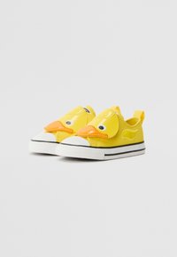 Kollaste laste sneakersite esiosas on partehha vaade, must-valgete triibuliste tallade ja kontsade peal on tõmblukud.