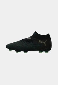 Black soccer cleat featuring a sleek design, textured pattern, green accents on the sole, and a knitted collar for a snug fit.